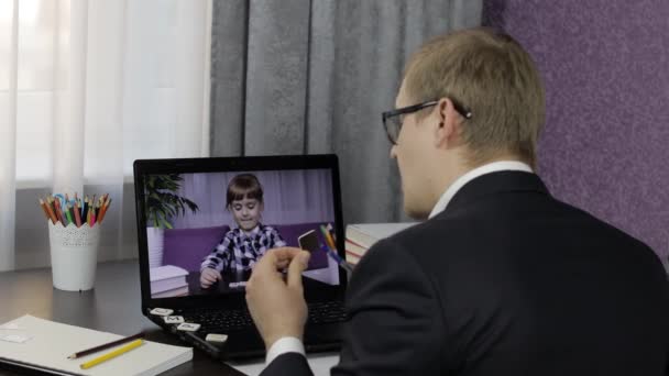 Hombre profesor haciendo videollamada en el portátil con pequeño alumno. Educación a distancia — Vídeos de Stock