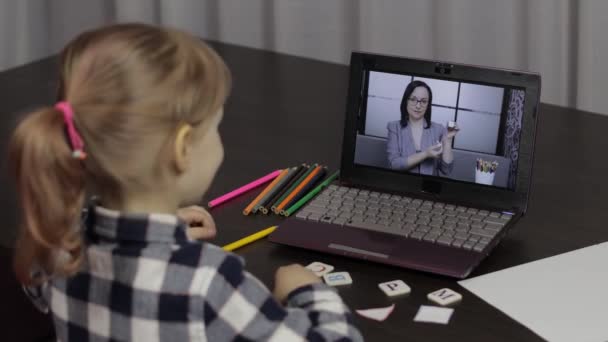 Lección de la educación a distancia de la muchacha con la maestra, usando el ordenador portátil digital en casa — Vídeos de Stock