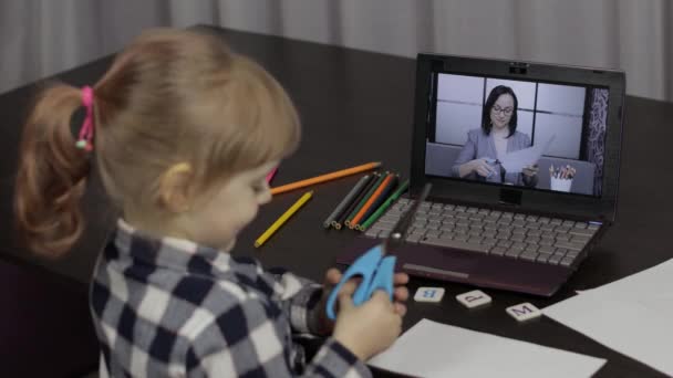 Урок дистанционного обучения девочек с учительницей-женщиной, с помощью цифрового ноутбука дома — стоковое видео
