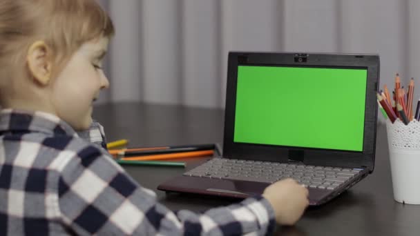 아이들은 집에서 온라인 수업을 받는 동안 노트북으로 교육을 받습니다. 녹색 화면 — 비디오
