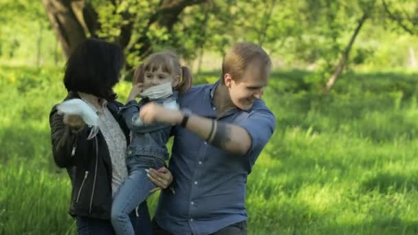 Семья в парке снимает медицинские маски после окончания пандемии коронавируса — стоковое видео