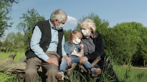 Nonni con nipote in maschere mediche nel parco. Quarantena del coronavirus — Video Stock