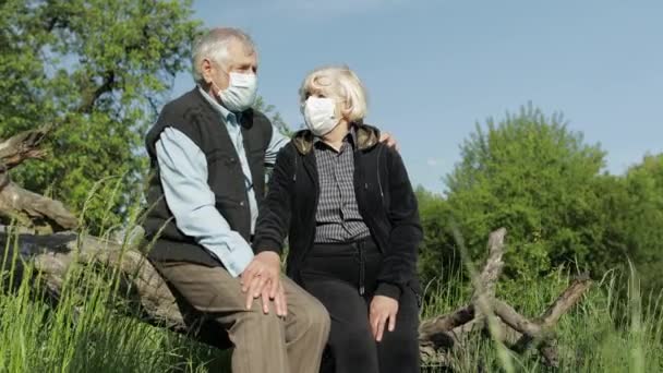 Oudere paren met medische maskers tijdens COVID-19 coronavirus quarantaine in het park — Stockvideo