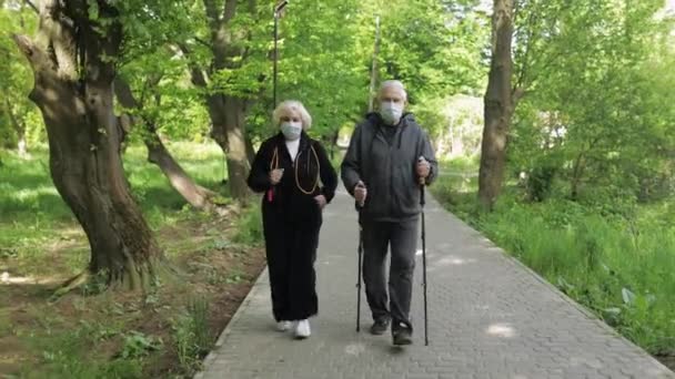 Aktiv äldre man, kvinna utbildning Nordic walking in park under karantän — Stockvideo