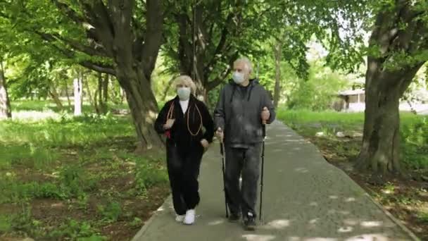 Aktive Seniorin trainiert während Quarantäne Nordic Walking im Park — Stockvideo