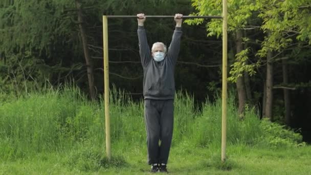 Активний старший чоловік робить розтягування фізичних вправ в коронавірусному карантині — стокове відео