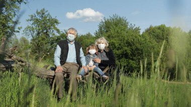 Torunları ve büyük babaları parkta maske takıyorlardı. Coronavirus karantinası