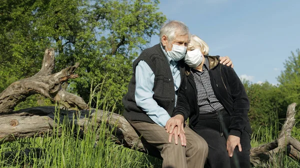 COVID-19 koronavirüs karantinası sırasında maskeli yaşlı çift parkta