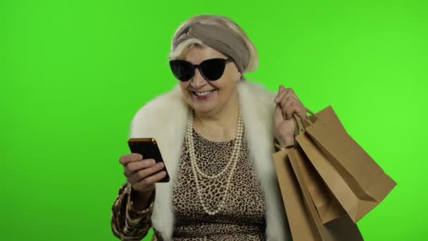 शॉपिंगसाठी स्मार्टफोन वापरणारी वृद्ध काकेशियन आजी. क्रोमा की — स्टॉक व्हिडिओ
