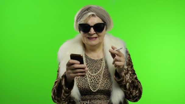 Anziani alla moda donna nonna caucasica alla moda utilizzando smartphone. Chiave cromatica — Video Stock