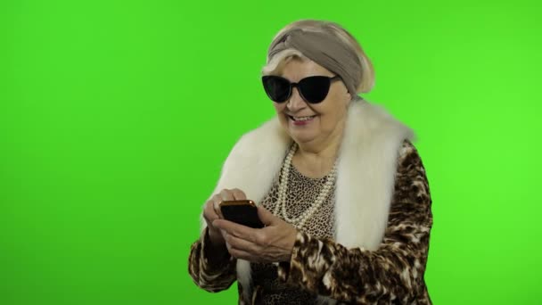 Femme grand-mère caucasienne utilisant un smartphone, pointant quelque chose avec la main — Video