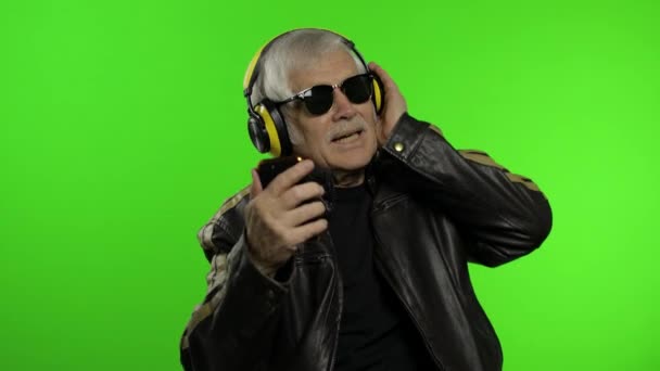 Starszy biały dziadek motocyklista tańczy, słucha muzyki. Klucz chromowy — Wideo stockowe