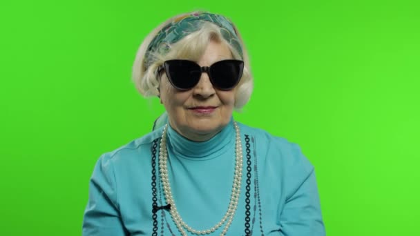 Старая стильная бабушка. Белая женщина позирует на фоне хроматического ключа — стоковое видео