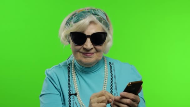 Äldre eleganta kaukasiska mormor kvinna med hjälp av sociala medier app på smartphone — Stockvideo