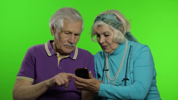 Volwassen oud paar grootouders genieten van online winkelen op mobiele telefoon — Stockvideo