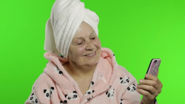 Ηλικιωμένη γιαγιά μετά το ντους. Γριά γυναίκα κάνει selfies χρησιμοποιώντας το κινητό τηλέφωνο — Αρχείο Βίντεο