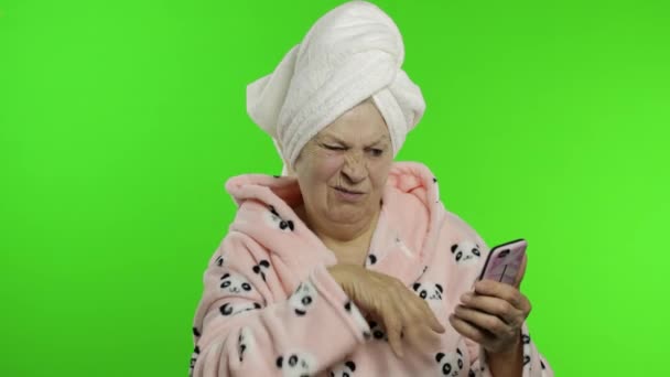 Ηλικιωμένη γιαγιά μετά το ντους. Γριά γυναίκα που χρησιμοποιεί smartphone για online ψώνια — Αρχείο Βίντεο