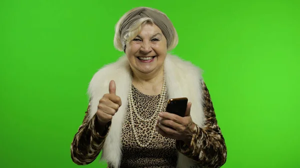 Anziani caucasico nonna donna utilizzando smartphone per lo shopping. Chiave cromatica — Foto Stock