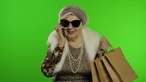 Пожилая белая бабушка с помощью смартфона. Делай покупки. Ключ хрома — стоковое фото
