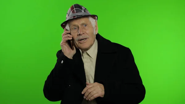年长时尚的高加索祖父，用智能手机在网上购物 — 图库照片