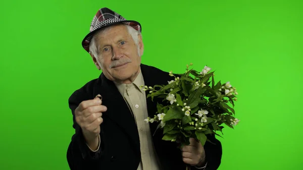 Starszy biały dziadek człowiek z bukietem kwiatów i pierścień idzie na datę — Zdjęcie stockowe