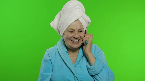 Duştan sonra yaşlı büyükanne. Cep telefonuyla konuşan yaşlı bir kadın. Krom anahtar — Stok fotoğraf