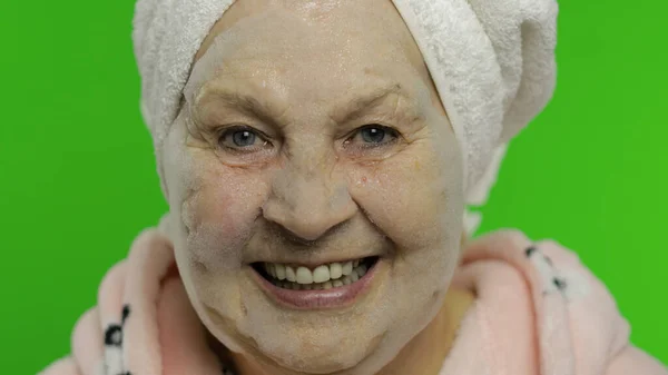 Abuela mayor después de la ducha. Mujer vieja aplicando mascarilla cosmética de burbuja —  Fotos de Stock