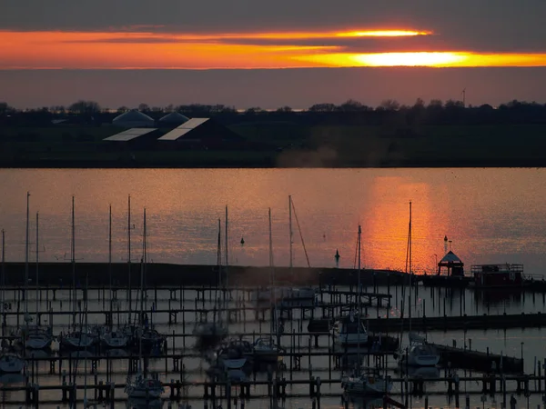 Sonnununtergang ueber dem Yachthafen vor Saisonstart  
