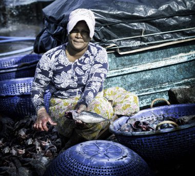 Negombo, Sri Lanka - 13 Ocak 2020: Negombo 'daki balık pazarında balık temizleyen orta yaşlı Sri Lankalı kadın. Balık pazarındaki işçilerin günlük işleri.