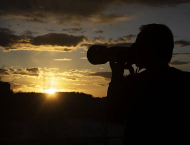 Fotoğrafçı, gün batımından sonra DSR kamerasında fotoğraf çekiyor. Şehir alacakaranlığı, panoramik manzara. Düşük ışık, alacakaranlık.
