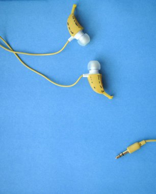 Mavi arka planda sarı kulaklıklar.