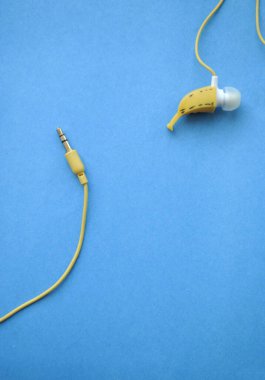 Mavi arka planda sarı kulaklıklar.