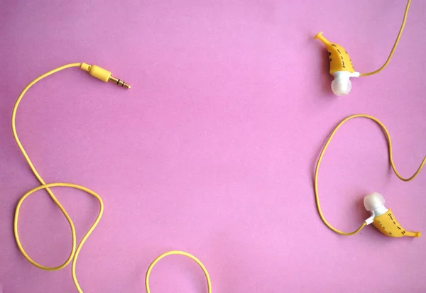 Ακουστικά Στο Αυτί Σχήμα Μπανάνας Φωτεινό Φόντο — Φωτογραφία Αρχείου