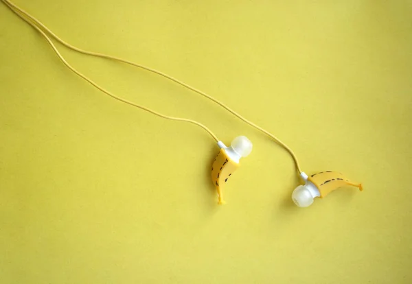 in-ear headphones in the shape of a banana on a bright background