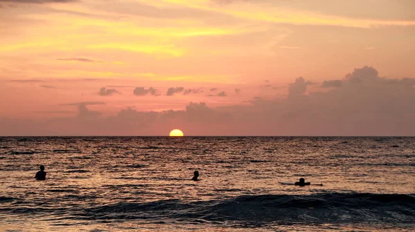 Jugando en la playa al atardecer, tomada cuando la luz es muy baja —  Fotos de Stock