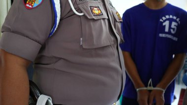 Polis tarafından sorgulanan suçlular elleri kelepçeli, Pekalongan Endonezya 