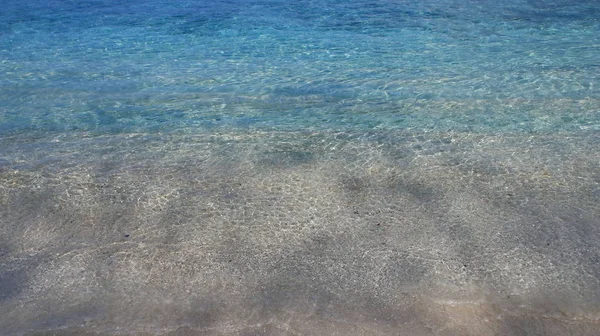 Acqua limpida vicino alla spiaggia con onde — Foto Stock