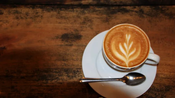 Capucino koffie in een kopje op een houten tafel — Stockfoto