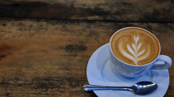 Capucino koffie in een kopje op een houten tafel — Stockfoto