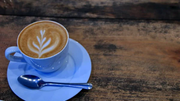 Capucino koffie in een kopje op een houten tafel — Stockfoto