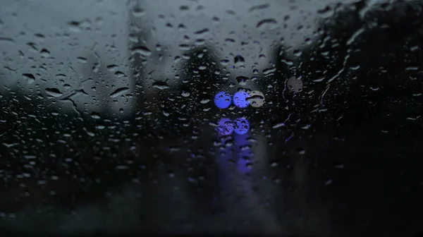 车辆和灯火通明 雨滴落在挡风玻璃窗上 — 图库照片
