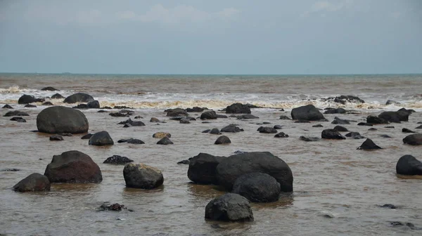 Ondes violentes sur la plage qui frappent le corail noir avec une concentration sélective — Photo