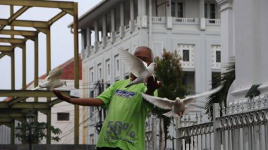 9 Ocak 2020 'de, Semarang Endonezya' da, güvercinlerle sohbet etmeyi ve onlarla beslenmeyi seven yaşlı bir adam.