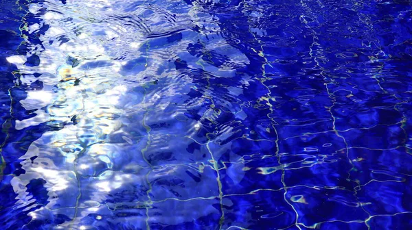 水面反射波纹和太阳光的游泳池水的背景 — 图库照片