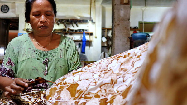 Activity of making batik,  Create and design white fabric using canting and malam by slamming over the fabric, Pekalongan, Indonesia, March 7, 2020