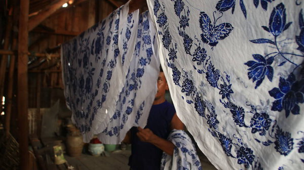 Activity of making batik,  Create and design white fabric using canting and malam by slamming over the fabric, Pekalongan, Indonesia, March 7, 2020