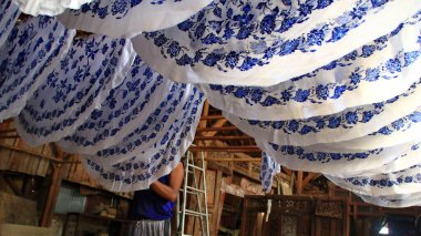  Activity of making batik,  Create and design white fabric using canting and malam by slamming over the fabric, Pekalongan, Indonesia, March 7, 2020 clipart