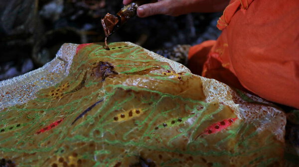  Activity of making batik,  Create and design white fabric using canting and malam by slamming over the fabric, Pekalongan, Indonesia, March 7, 2020