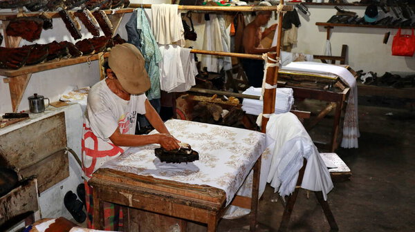  Activity of making batik,  Create and design white fabric using canting and malam by slamming over the fabric, Pekalongan, Indonesia, March 7, 2020