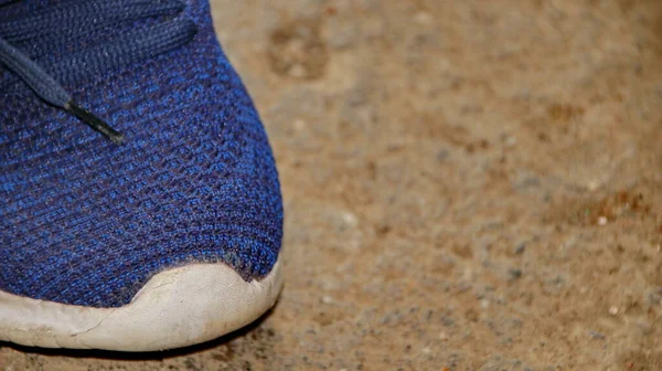 Blurred image out of focus images blue colored plastic shoes on a dirty cement floor